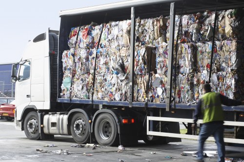 Worker in high visibility clothing preparing to clear a cluttered room